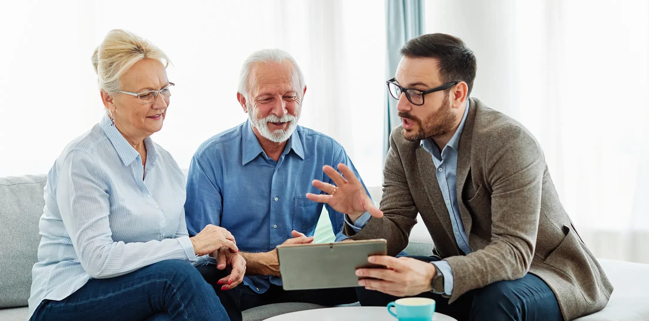 An advisor discussing information on a tablet with two clients