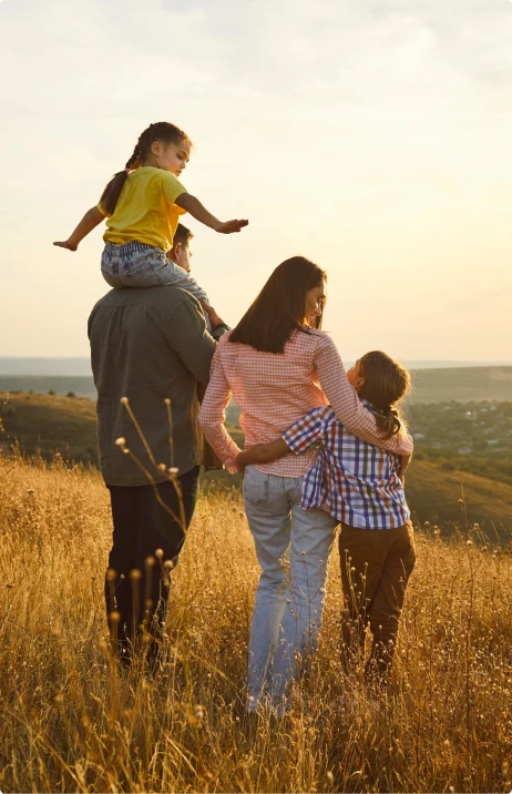 A family overlooking a landscape at sunset